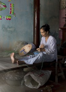 A woman repairing fishing nets, Long Hai Beach