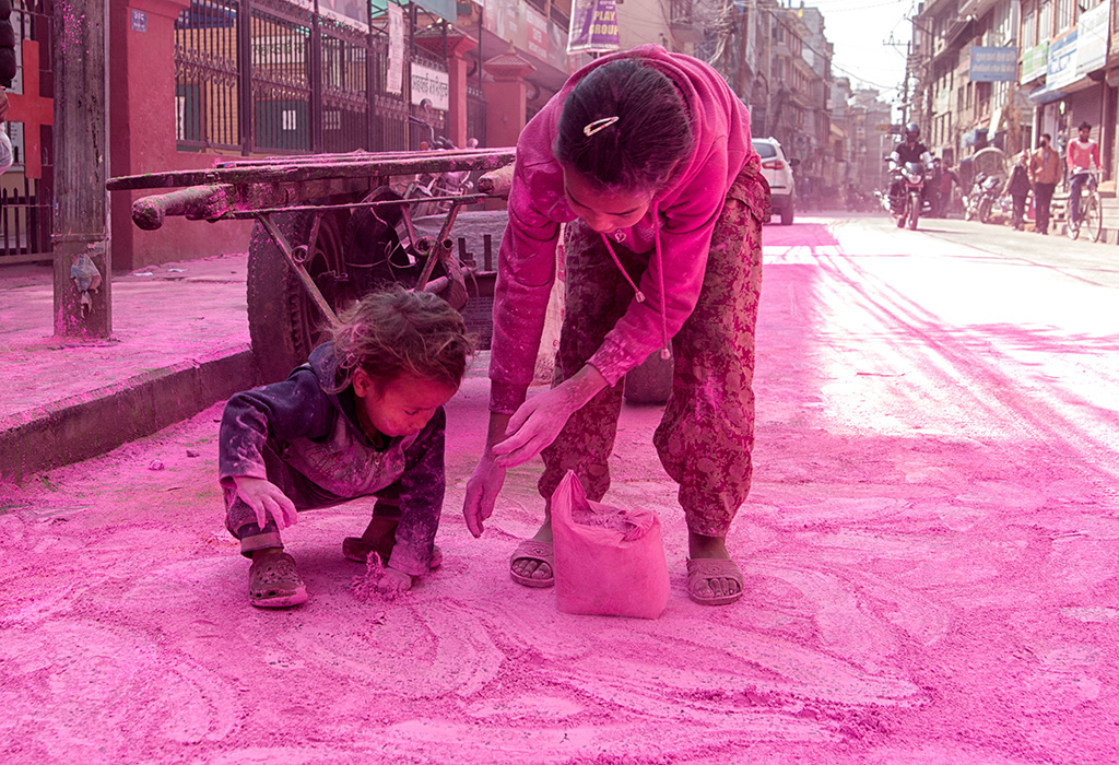 Children collecting colored powder on the roads