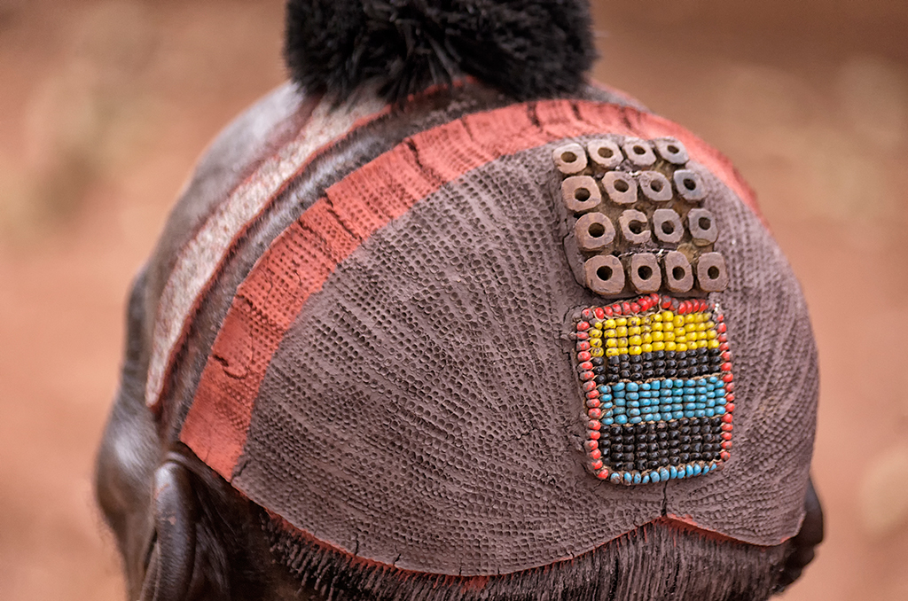 The Benna Tribal Chief's hairdressing is made from a mixture of clay and grounded hematite. Feathers are usually placed into the small 'ornaments' on their head during celebrations.