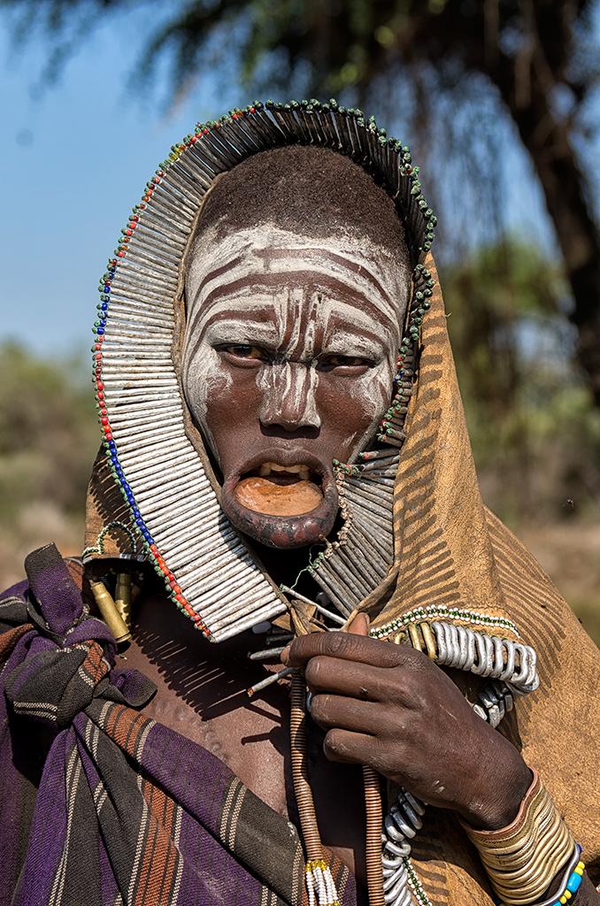 A Mursi woman with a small lip plate who will soon  progress onto inserting a six-inch plate into her lip